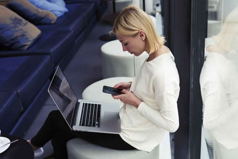 woman on phone with laptop